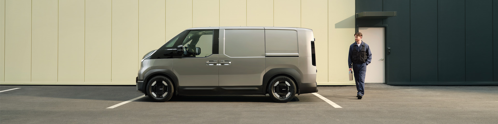 Der Kia PV5 Cargo in Seitenansicht mit Talent im Overall